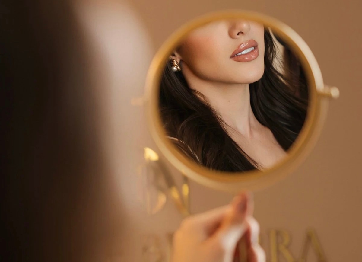 Reflexo de paciente em espelho — resultado de tratamento estético facial
